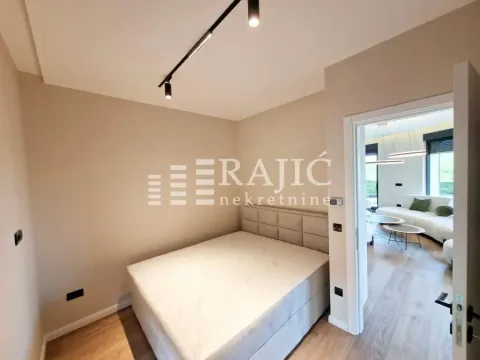Modern bedroom with a double bed and a view into the living room. - image 8