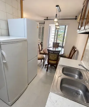 Manja kuhinja sa sudoperom, frižiderima i trpezarijom u pozadini. - image 5