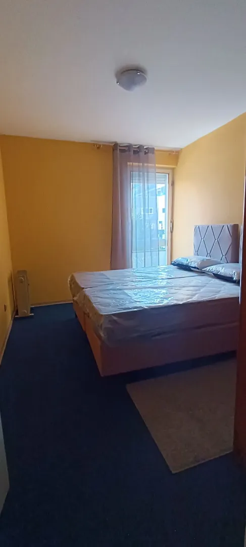 Spavaća soba sa bračnim krevetom prekrivenim zaštitnom folijom.