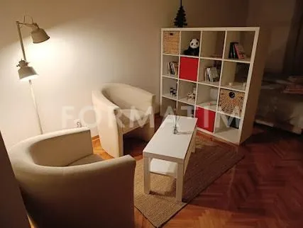 Manji dnevni boravak sa foteljama, stočićem i policom za knjige.