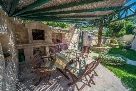 Natkrivena terasa sa kamenim roštiljem i garniturom za sjedenje u dvorištu. - image 2