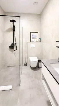 Modern bathroom with walk-in shower, washbasin, and toilet in light tones. - image 6