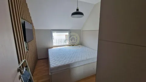 Manja spavaća soba sa bračnim krevetom, drvenim zidnim panelima i krovnim prozorom. - image 6
