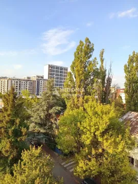 Pogled sa prozora na okolne zgrade i zelene krošnje drveća. - image 5