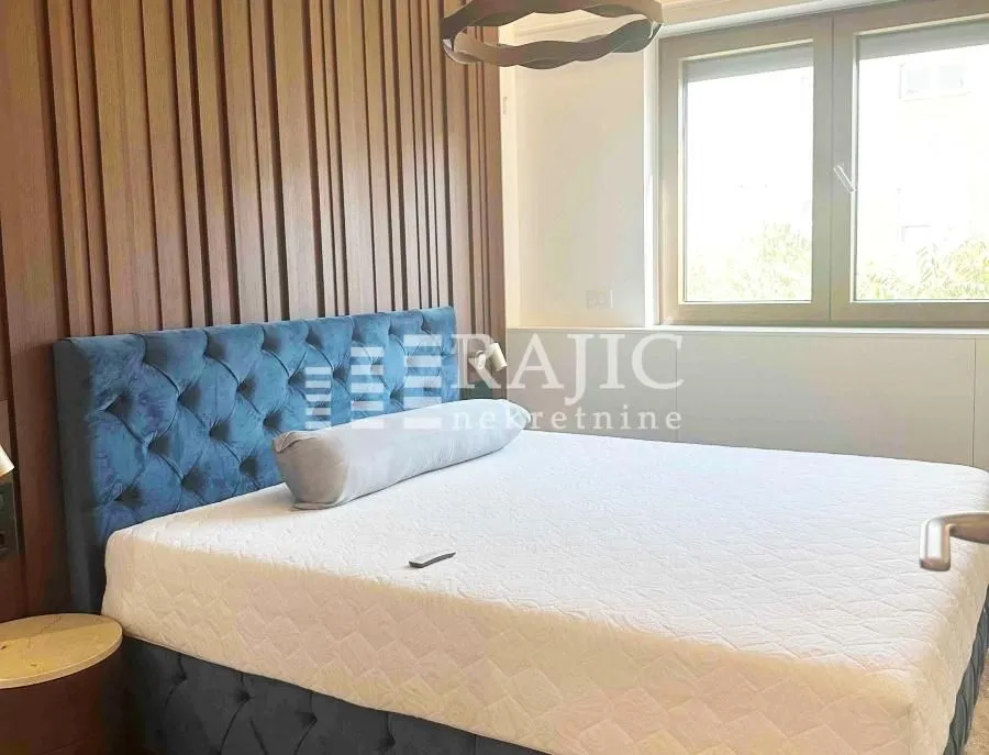 Modern bedroom with a double bed and wooden wall paneling.