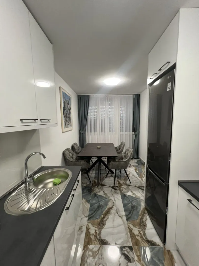 Bright kitchen with a dining area and modern floor tiles.