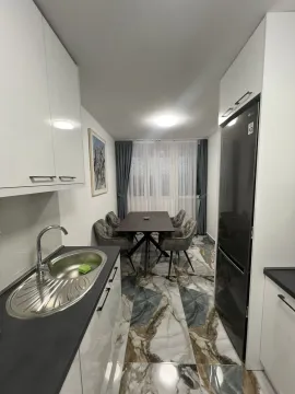 Bright kitchen with a dining area and modern floor tiles. - image 3