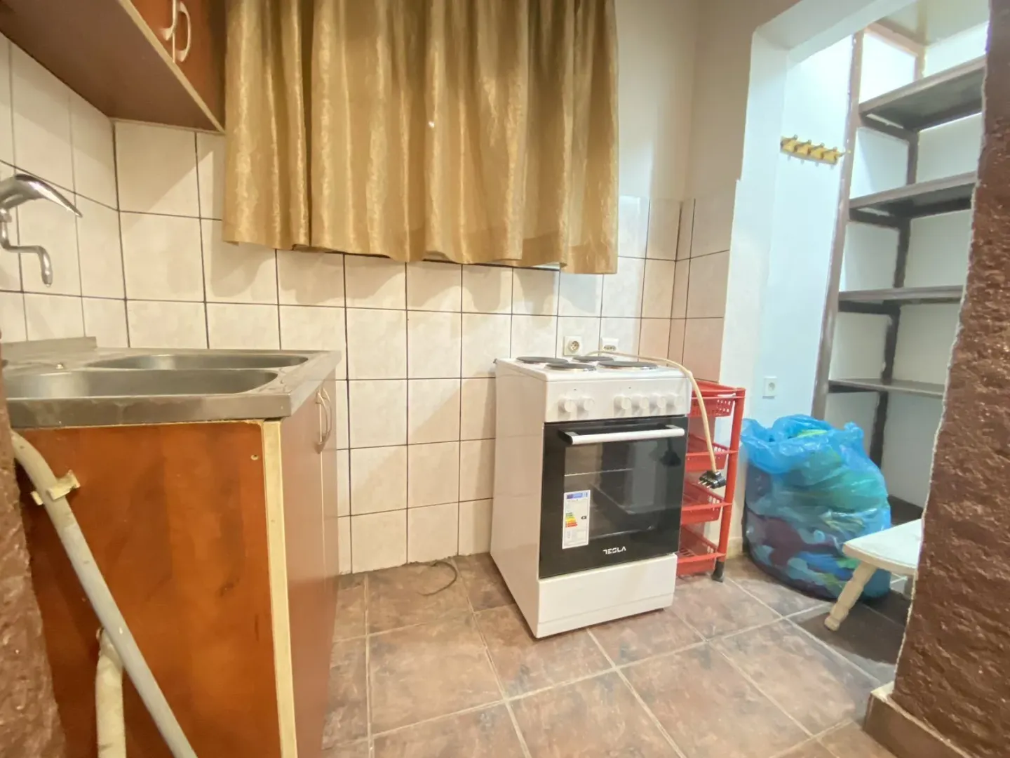 Mala funkcionalna kuhinja sa električnim šporetom i sudoperom.