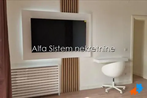 Dnevni boravak sa montiranim televizorom na zidu i radnim stolom. - image 8