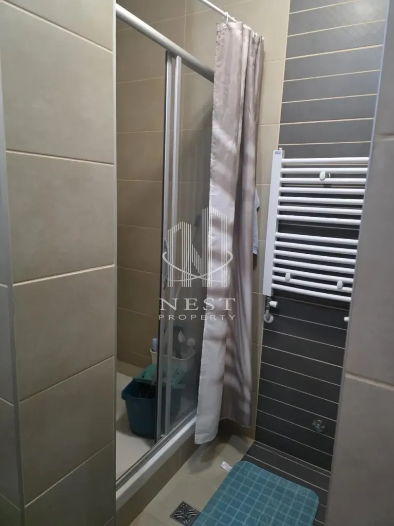 Bathroom with a shower cabin and a towel radiator.
