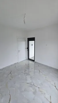 Prazna prostorija sa svijetlim keramičkim pločicama na podu i bijelim zidovima. - image 4