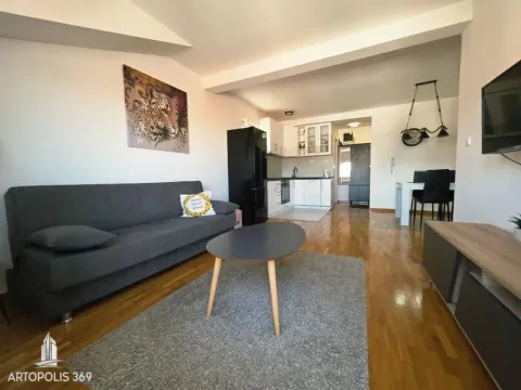 Spacious living room with a sofa and a view towards the kitchen and dining area. - image 3
