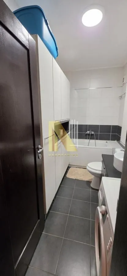 Pregledno kupatilo sa kadom, umivaonikom i ugrađenim elementima.