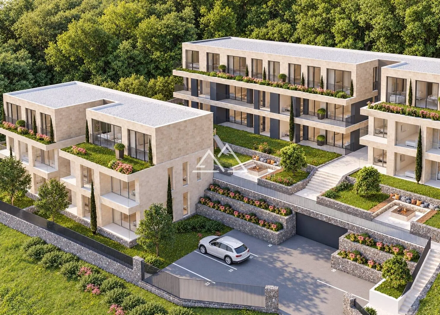 Aerial view of a residential building complex with landscaped courtyard and parking.
