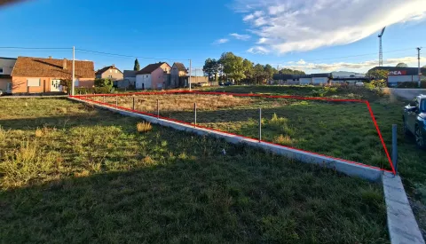 Pogled na ograđeni građevinski plac sa okolnim kućama. - image 2