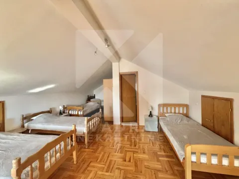 Attic bedroom with multiple wooden beds and parquet flooring. - image 10