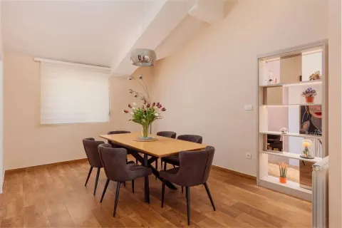 Trpezarija sa drvenim stolom i modernim tamnim stolicama. - image 3