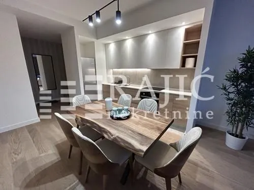 Modern kitchen with dining area and built-in appliances.