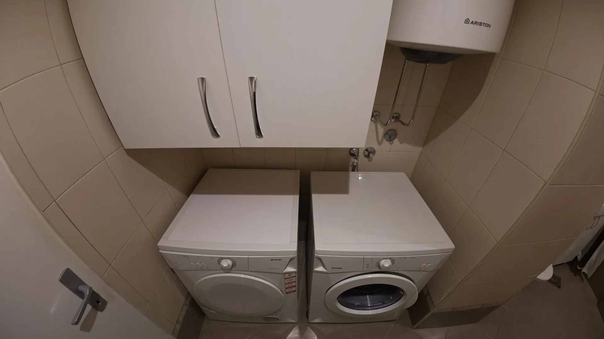 Bathroom with washing machines and a water heater.