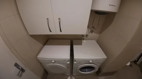 Bathroom with washing machines and a water heater. - image 7