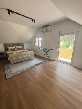 Attic bedroom with a double bed, wooden floor, and balcony access. - image 5