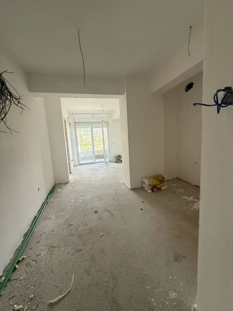 Interior of an unfurnished apartment under construction with a view of the terrace.