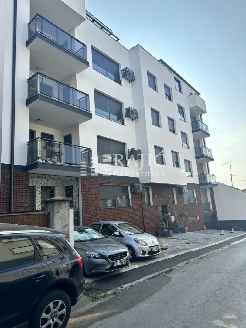 Exterior view of a modern residential building with balconies and parking.