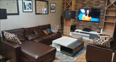 Dnevna soba sa ugaonom garniturom, stočićem i televizorom na zidu. - image 2
