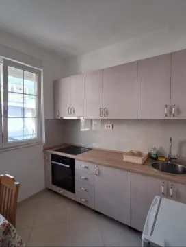 Small bright kitchen with wooden cabinets and built-in appliances. - image 4
