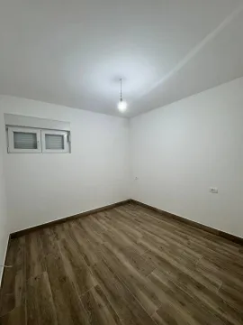 Prazna soba sa bijelim zidovima i drvenim podom. - image 5