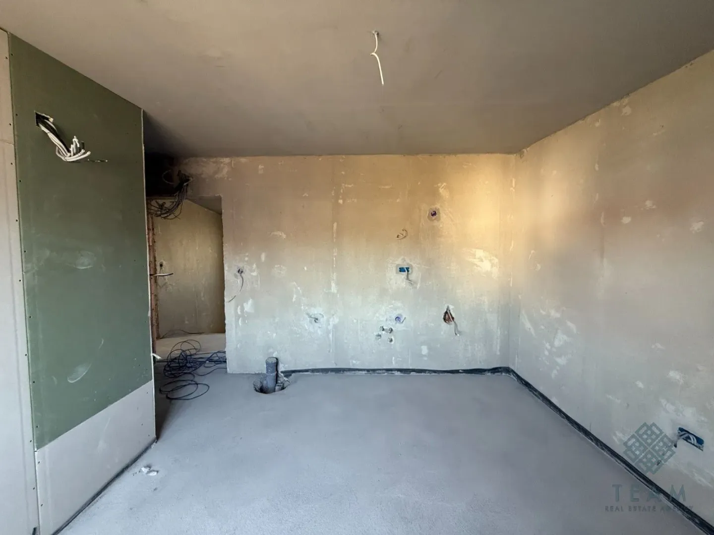 Pogled na praznu prostoriju u sivoj fazi sa pripremljenim instalacijama.