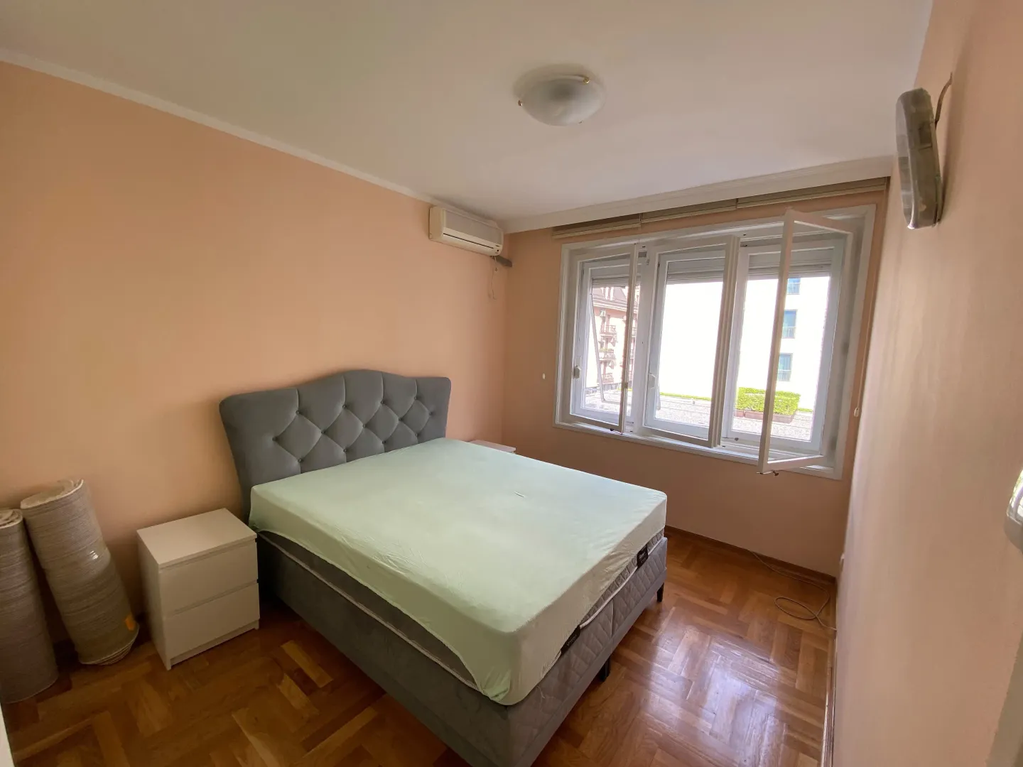 Spavaća soba sa bračnim krevetom, noćnim stočićima i prozorom.