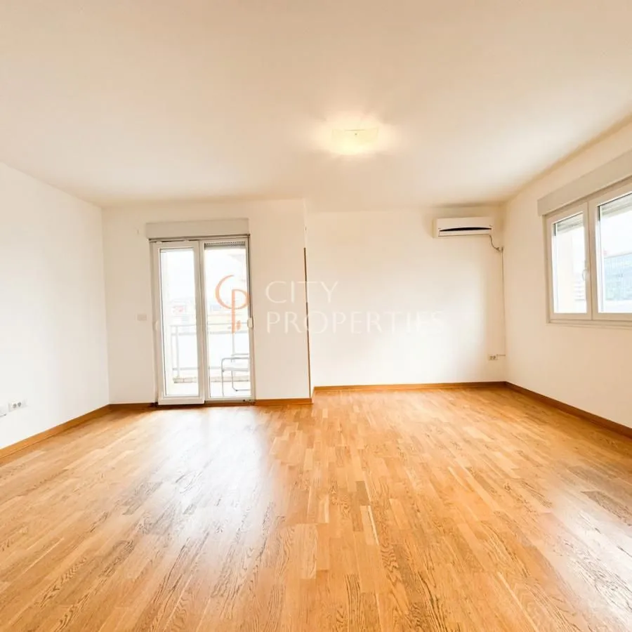 Empty room with wooden flooring, air conditioning unit, and access to the terrace.