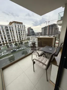Natkriveni balkon sa stolom i stolicama i pogledom na grad. - image 10