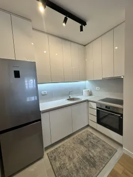 Moderna bijela kuhinja sa ugradnim aparatima i frižiderom. - image 2