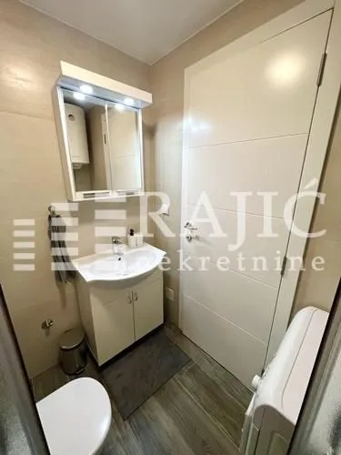 Small bathroom with a sink, toilet, and white door.
