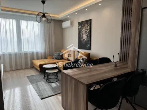 Dnevna soba sa garniturom, trpezarijskim stolom i ukrasnim elementima na zidu. - image 3