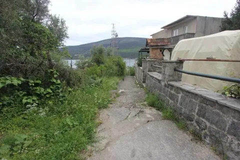 Prilazni put do kuće okružen zelenilom sa pogledom na more u daljini. - image 7