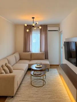 Living room with a corner sofa, coffee table, and TV. - image 2