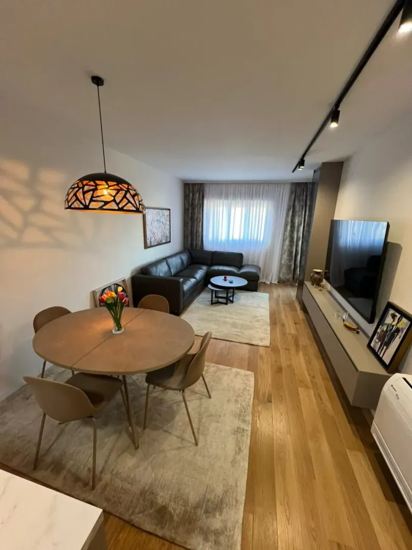 Living room with dining area, sofa set, and television.