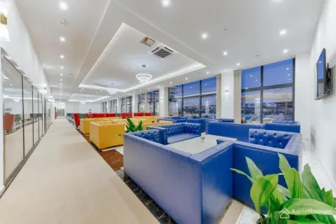Spacious living room with comfortable seating arrangements and large windows. - image 10