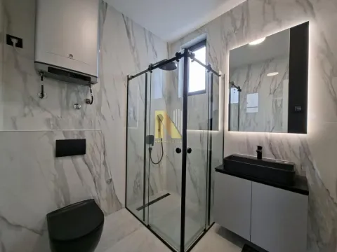 Moderno kupatilo sa tuš kabinom, umivaonikom i wc šoljom obloženo mermernim pločicama. - image 7