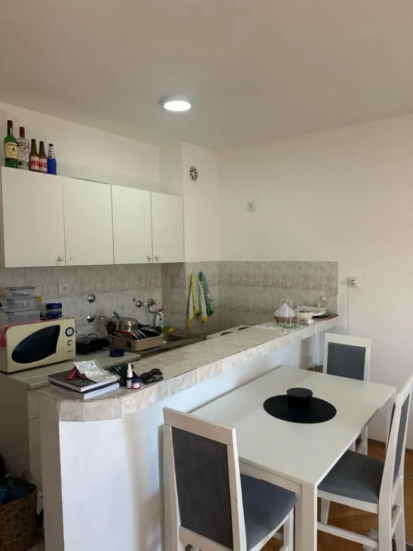 Smaller kitchen with a breakfast bar and dining table.