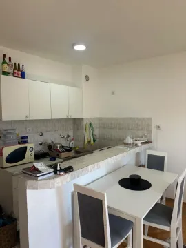 Smaller kitchen with a breakfast bar and dining table. - image 4