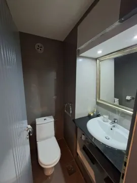 Smaller bathroom with a washbasin, mirror, and toilet. - image 9