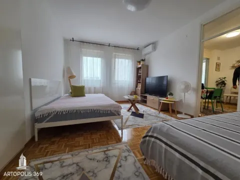 Spavaća soba sa krevetom, televizorom i parketom na podu. - image 6