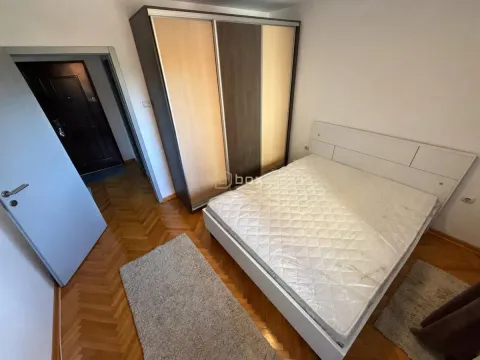 Bedroom with a double bed, a large wardrobe, and parquet flooring. - image 11