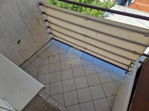 Small tiled balcony with a railing and a protective screen. - image 8