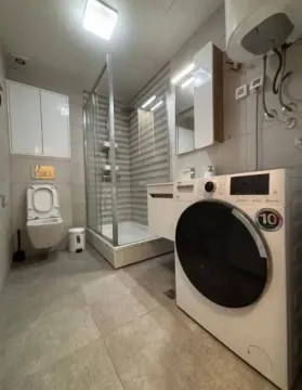 Savremeno opremljeno kupatilo sa tuš kabinom i veš mašinom. - image 10