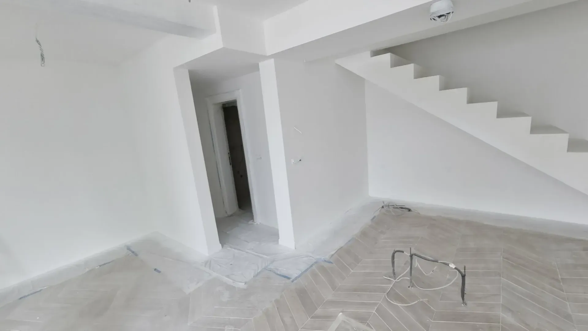 Prazan prostor u izgradnji sa stepeništem i drvenim podom.